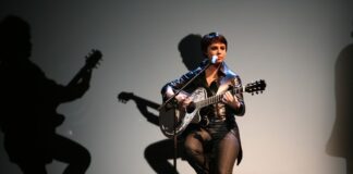 Woman on chair with a guitar doing not a lot of anything 4Fun