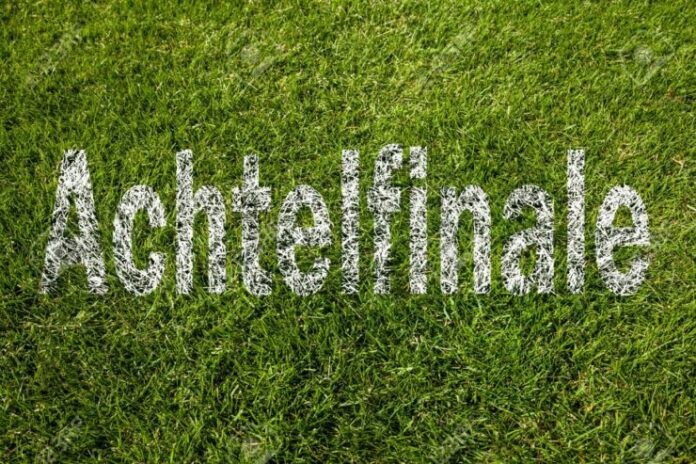"Round of sixteen" (in German) written on a soccer meadow